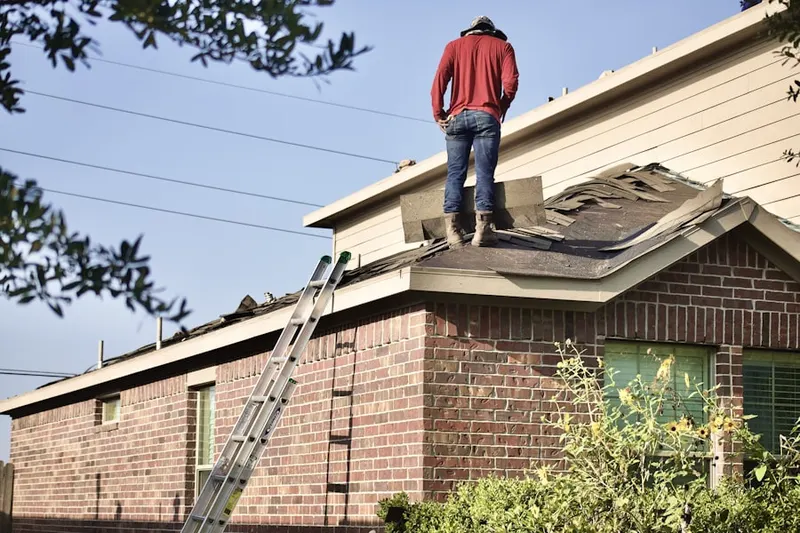 Professional roofer working on a residential roof in Shaw